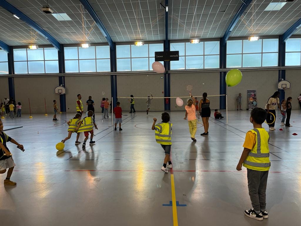 Enfnat avec des gilets jaunes qui jouent au badminton dans le Gymnase Valmy à Toulouse